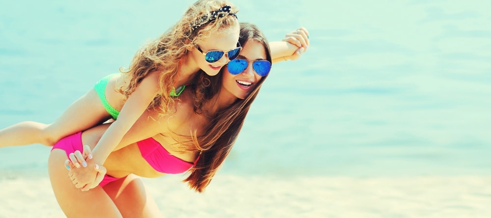 Mom in bikini with slim, toned abs from postpartum tummy tuck in Salt Lake City, UT